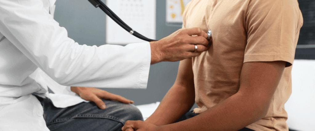 Doctor listening to male patient heart with stethoscope