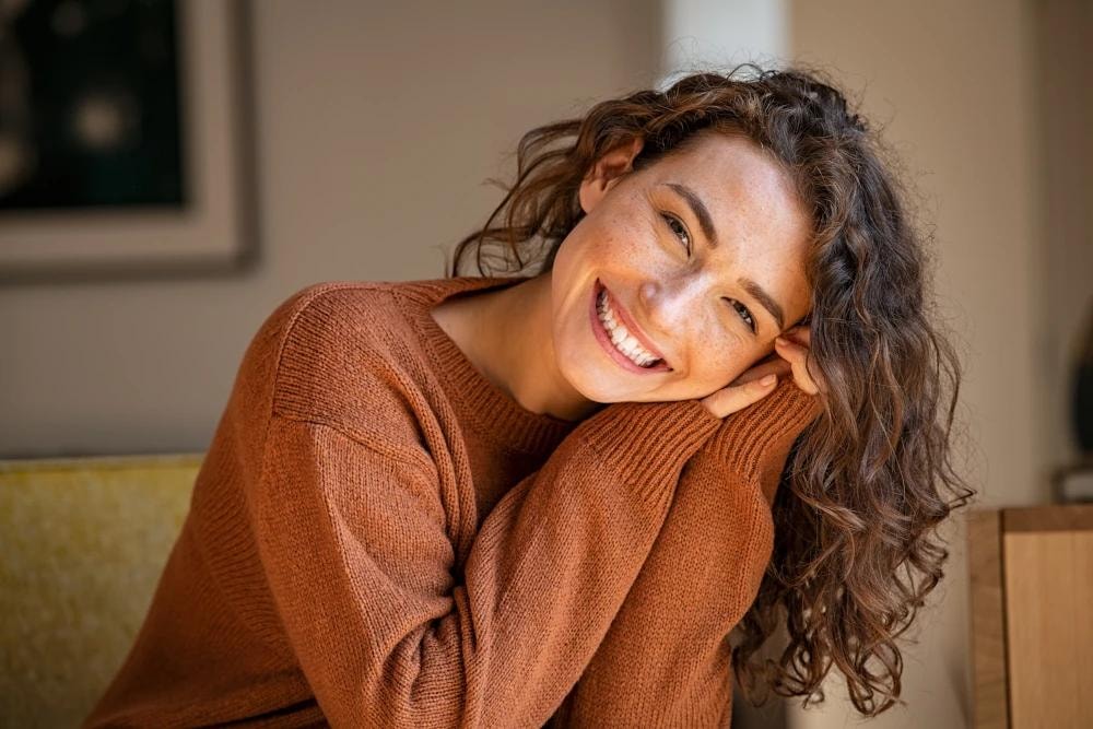 Woman smiling warmly indoors